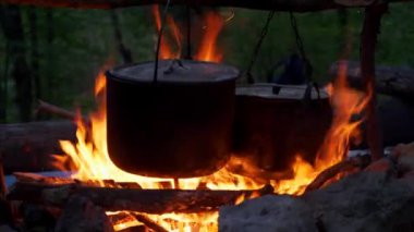 Alacakaranlıkta kamp ateşinde bir demlik