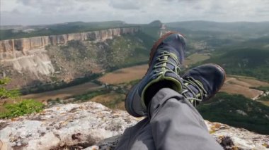 Arka planda dağlar olan dinlenme yürüyüşçülerinin yakın çekim ayakları.