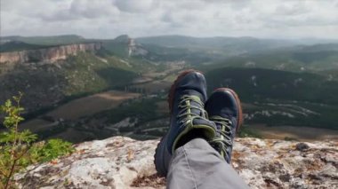 Arka planda dağlar olan dinlenme yürüyüşçülerinin yakın çekim ayakları.