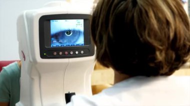 Optisyen doktor kırılma makinesiyle çalışıyor..