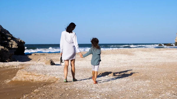 Madre con hija está caminando en la playa juntos. — Foto de Stock