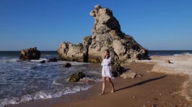 Genç ve çekici bir kadın sahilde yalnız yürüyor..