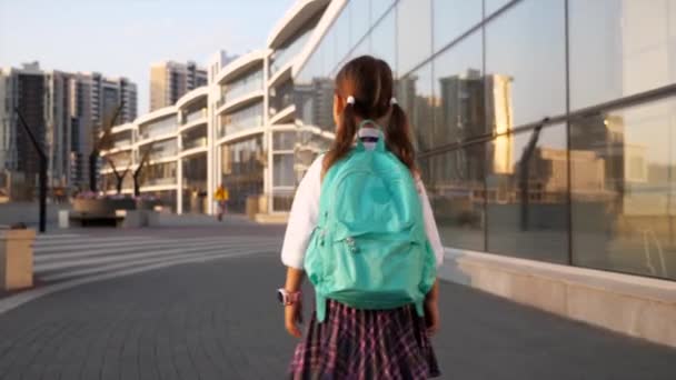 Pequeno aluno de uniforme escolar vai para a escola na paisagem da cidade — Vídeo de Stock
