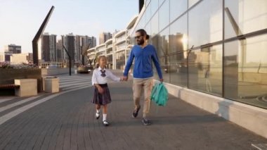 Babası ve üniformalı kızı sabah okula gidiyorlar.