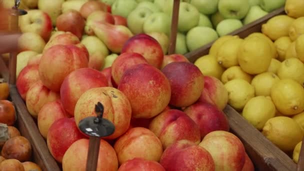 Крупным планом продуктовый работник организует органические фрукты на полках магазинов. — стоковое видео
