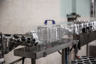 Bira fabrikasında bira şişeleme teknolojisi. Boş alüminyum bira kutuları taşıyıcı bant boyunca hareket ediyor. Temiz bira şişeleri taşıyıcı boyunca hareket ediyor. Endüstri, üretim hattı, kapatın..
