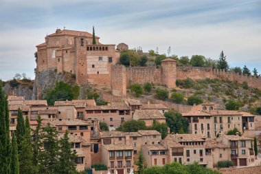 Huesca ilindeki bir ortaçağ İspanyol köyü olan Alquezar 'ın panoramik manzarası, sıcak tonlu taş evleri ve kayalık yamaçlar boyunca uzanan kil çatıları. Kompozisyon, tepenin üstündeki eski şatoyu ve kolej kilisesini ele geçiriyor.