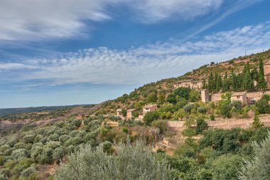 Huesca ilindeki bir ortaçağ İspanyol köyü olan Alquezar 'ın panoramik manzarası, sıcak tonlu taş evleri ve kayalık yamaçlar boyunca uzanan kil çatıları. Kompozisyon, tepenin üstündeki eski şatoyu ve kolej kilisesini ele geçiriyor.