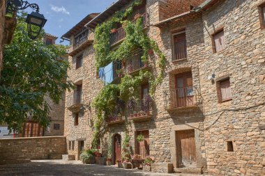 Ainsa, Huesca, İspanya-2 Eylül 2025, Ainsa 'nın ortaçağ kalbinden geçen kaldırımlı bir cadde, çok sayıda turist balkonlu ve mimari detaylarıyla taş binalarda gezinirken, Pireneler' de Aragon 'un tipik özelliklerini taşıyor.. 