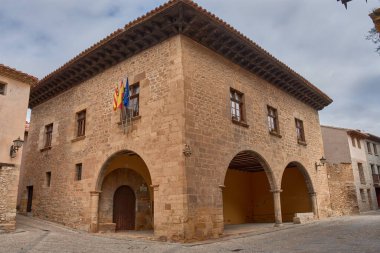 Topraksı ve kırmızımsı tonlara sahip taş binalar, güzel ortaçağ köyü Mirambel 'in özüdür ve ayrıntılı olarak zengin geleneksel bir mimariyi gözler önüne sermektedir. Duvarcılık cephesi, ahşap pencereler ve kapılar, işlenmiş demir balkonlar.