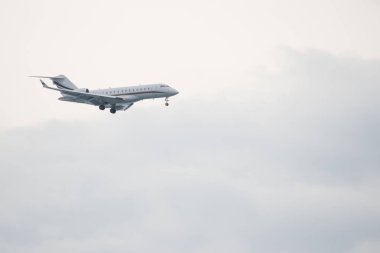 Beyaz bir arka planda beyaz bir uçak uçuyor