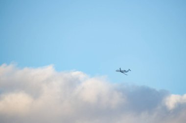 Bir beyaz ve mavi gökyüzü arka planda uçan beyaz uçak