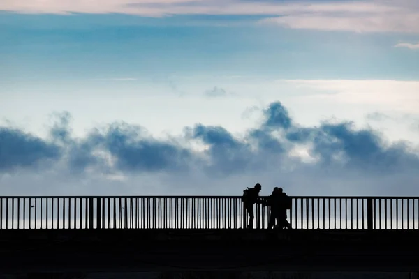 シルエット 川に架かる橋の上に立って人々 のグループ 黒と白 — ストック写真