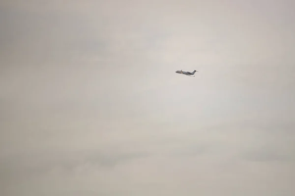 曇り空を飛行機飛行のシルエット — ストック写真