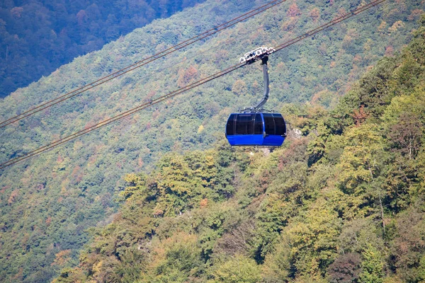 Cabine bleue pour le transport de passagers sur fond d'arbres verts — Photo