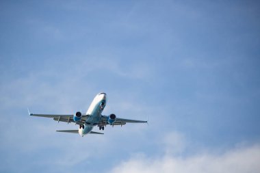 Beyaz bir gökyüzüne doğru uçan beyaz bir uçak