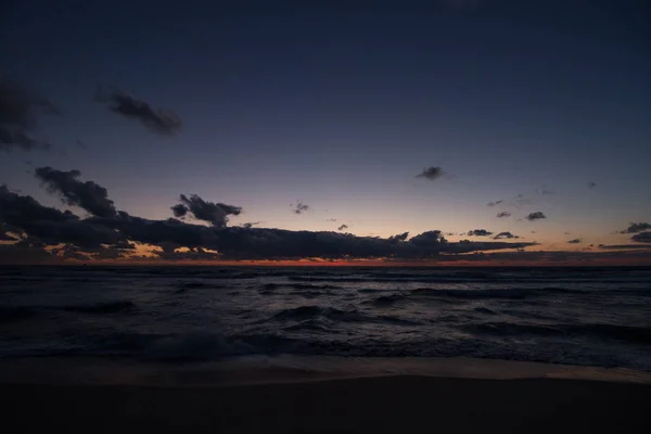 La puesta de sol desde un cielo nublado por la noche — Foto de Stock