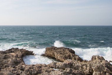 Deniz dalgaları kayalara çarpıyor. Gün