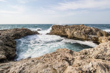 Deniz dalgaları kayalara çarpıyor. Gün