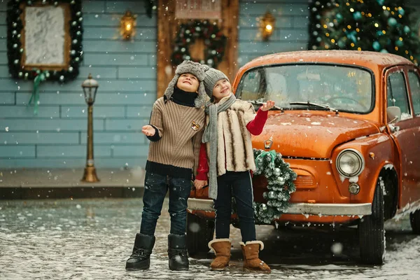 小机器人和女孩享受雪花户外附近老车 — 图库照片