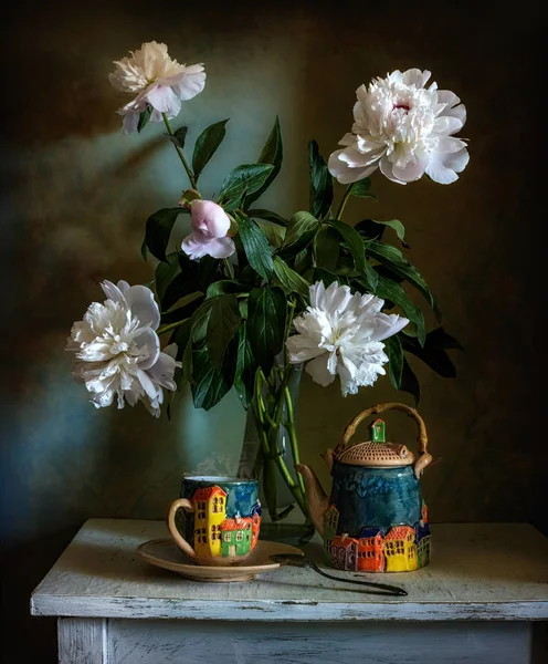 still life with flowers and a cup of tea. a bouquet of peonies. ceramics handmade.