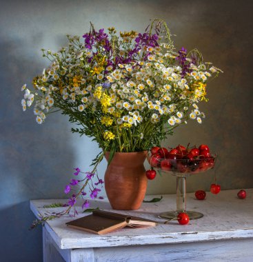 Natürmort çiçek, bir kitap ve bir kiraz. Vintage.
