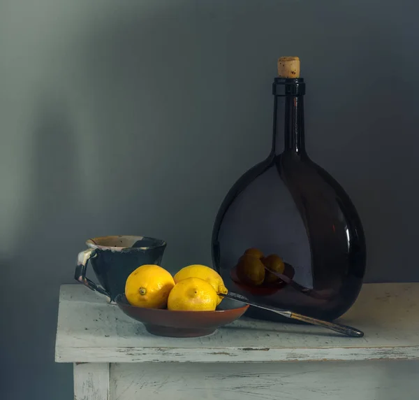 Limon ve bir şişe ile natürmort. Etüt. Minimalizm. Vintage.