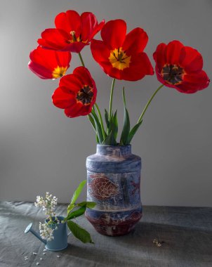 Bir buket lale ve sulama yla natürmort. Vintage.