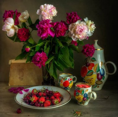 Bir buket çiçek, büyük, güzel bir sürahi, bir kupa komposto ve lezzetli çilekile natürmort. Peonies. Vintage.