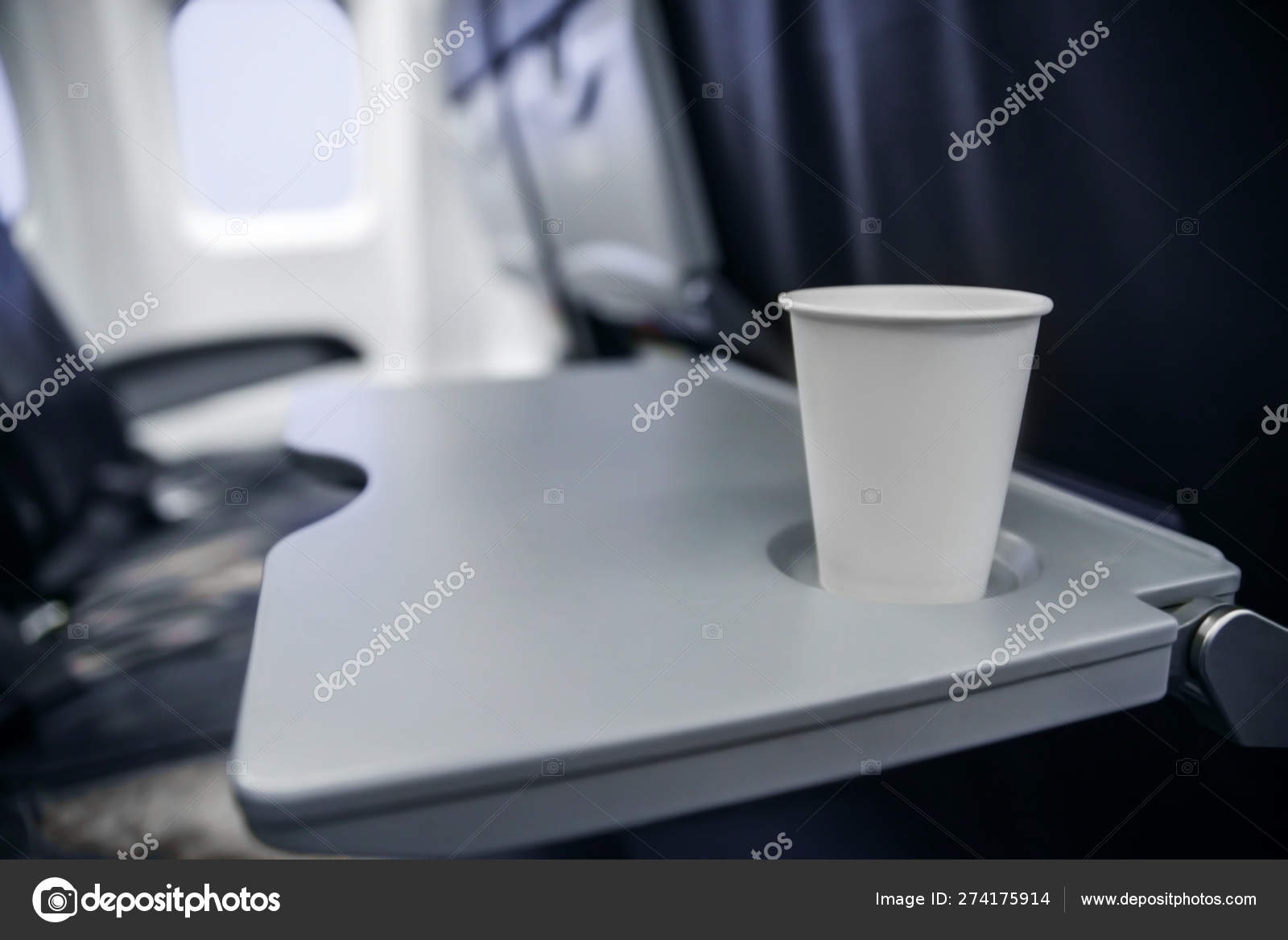 Plastic cup on the table in the plane during the flight. alcohol