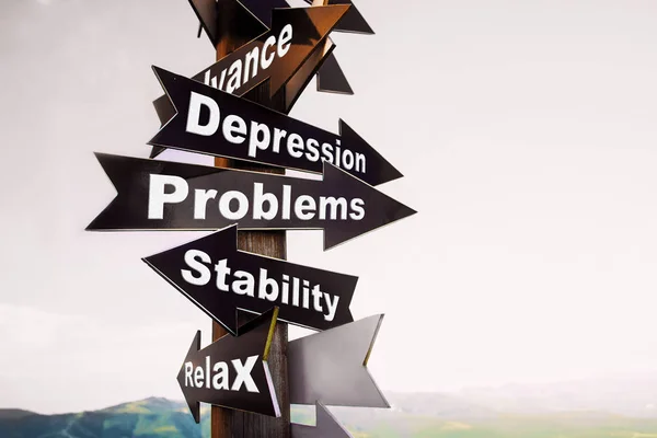 Wooden signpost with four arrows - depression, problems, stability, relax. The concept of choice.