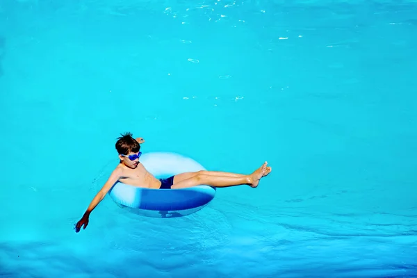 Вид сверху счастливый мальчик плавает на резиновом кольце, беззаботная концепция жизни — стоковое фото
