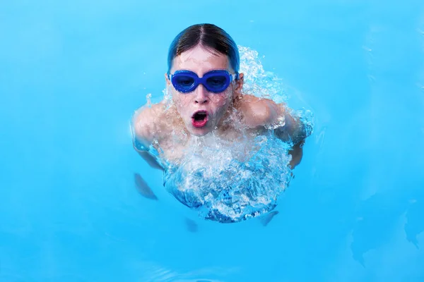 Mały sportowiec pływa w basenie przy raczku. Koncepcja szkolenia i sportu dla dzieci — Zdjęcie stockowe