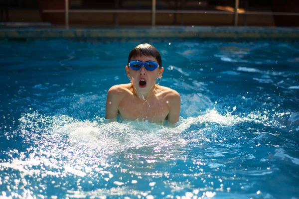 Ένα μικρό αγόρι κολυμπάει ενεργά στην πισίνα στην ύπαιθρο. Η έννοια του αθλητισμού και υγιεινό τρόπο ζωής. — Φωτογραφία Αρχείου