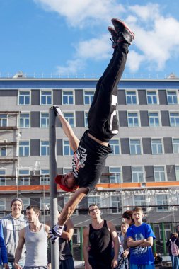 Norilsk, Rusya - 28 Ağustos 2016: Dışarıdaki yatay barda egzersiz yapan yakışıklı üstsüz adamın arka görünüşü. Jimnastik egzersizi..