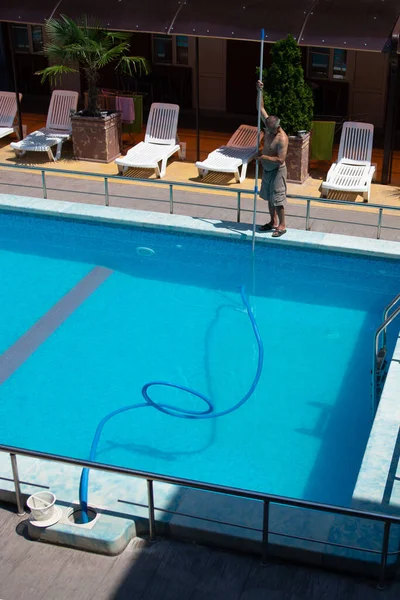 러시아아 나파, 2020 년 5 월 1 일: 수영장 청소. 남자가 수영장을 청소하고 있어요. 서비스 관리. — 스톡 사진