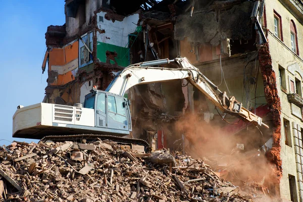 Kazıcı tuğla bir binayı yıkıyor. Makine Yıkım Binası