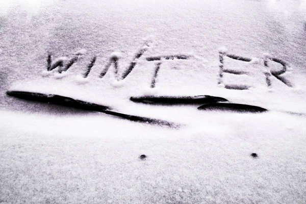 Hiver écrit dans la neige sur le pare-brise de voiture sous l'essuie-glace — Photo