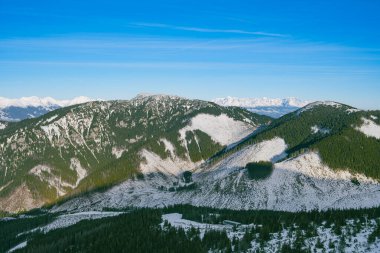 Yuvarlanan karlı yamaçlar, uzak tepeler ve alp ufuk çizgisiyle