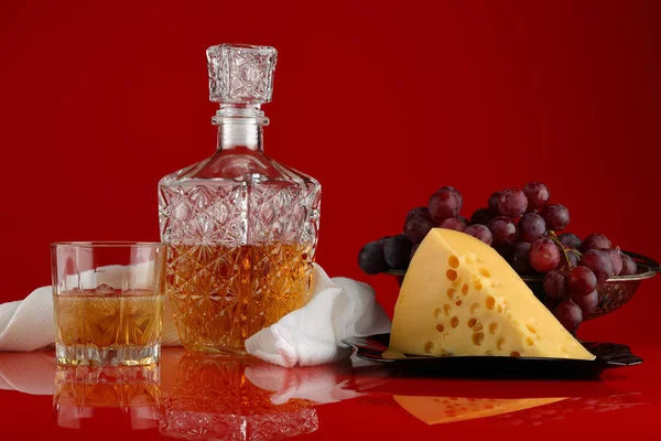 デカンタ ウィスキーのグラス チーズと光沢のある背景 ブルゴーニュのブドウの花瓶の静物 — ストック写真