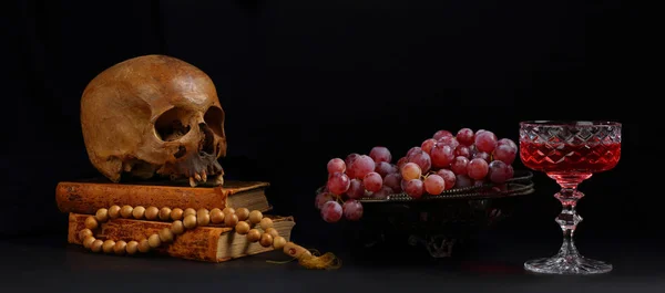 Ainda vida com um crânio, um vaso de uvas e um copo de vitória vermelha — Fotografia de Stock
