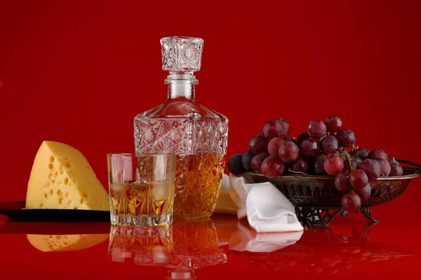 Stillleben mit einem Glas Whisky, Trauben und Käse — Stockfoto