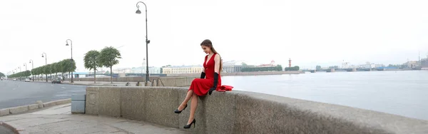 상트 페테르부르크의 궁전 제방에 빨간 드레스를 입은 소녀 — 스톡 사진