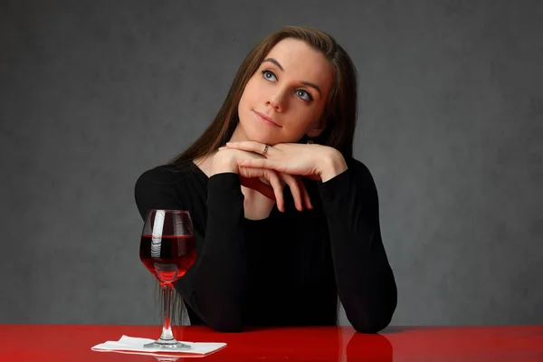 Мечтательная девушка и бокал красного вина — стоковое фото