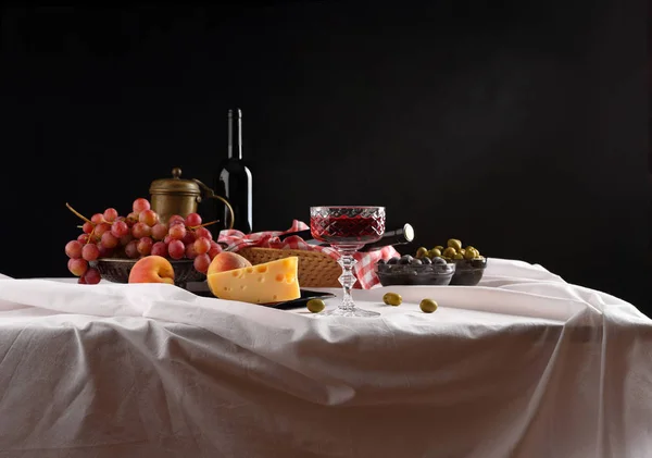 Panorama com um copo de vinho, azeitonas, queijo e uvas em um da — Fotografia de Stock