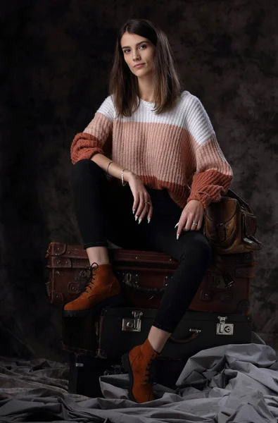 成長肖像画の美しいです女の子でA冬のセーター上のヴィンテージスーツケース — ストック写真
