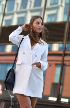 Modern cam bir binanın arka planında güzel bir kızın portresi.