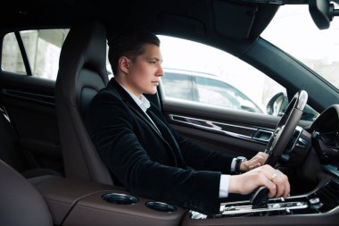 Uzmanları sadece ileri gidin! Yan görünüm portre yakışıklı kendine güvenen genç girişimci dikkatle otomobil sürüş.