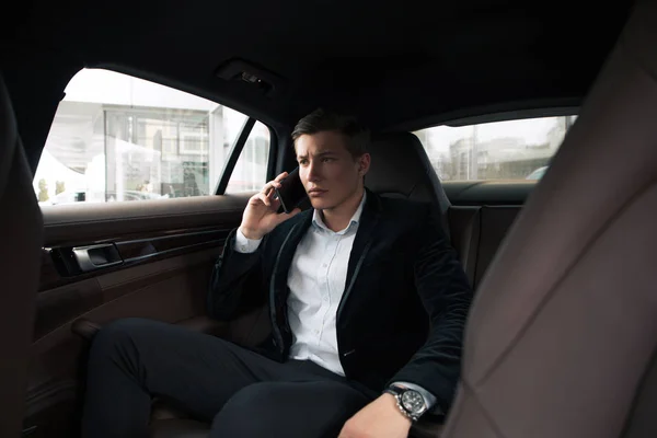 ¡Jefe serio! Joven hombre de negocios profesional inteligente hablando en serio en el teléfono inteligente, mientras que va a la oficina en coche . — Foto de Stock