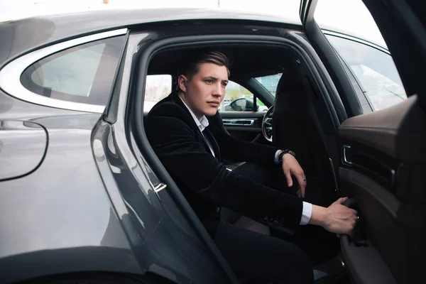 Soyez intelligent et intelligent ! Un beau jeune homme d'affaires sérieux assis dans sa nouvelle voiture confortable et allant au bureau . Images De Stock Libres De Droits